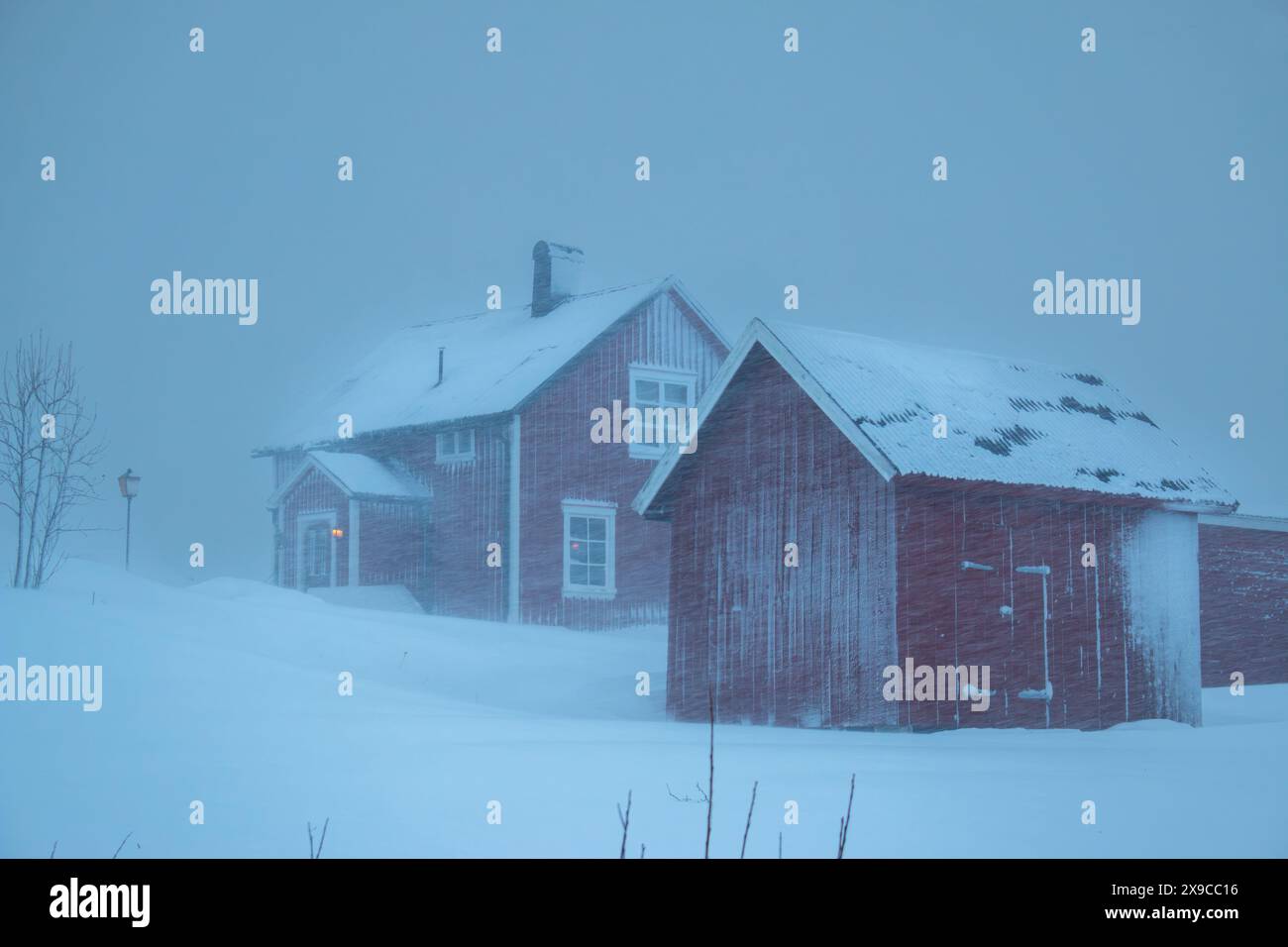 Case rosse svedesi in una delle tempeste di neve più forti del 2024, Hemavan, Svezia Foto Stock