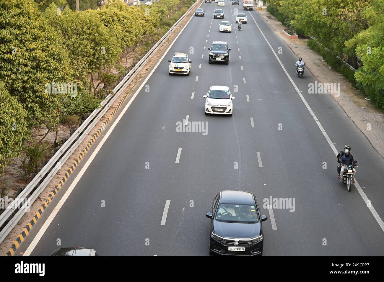 Mostra l'autostrada a sei corsie che si estende in lontananza, evidenziando il flusso fluido del traffico. #Road , #Expressway , #Cars, #Traffic Foto Stock