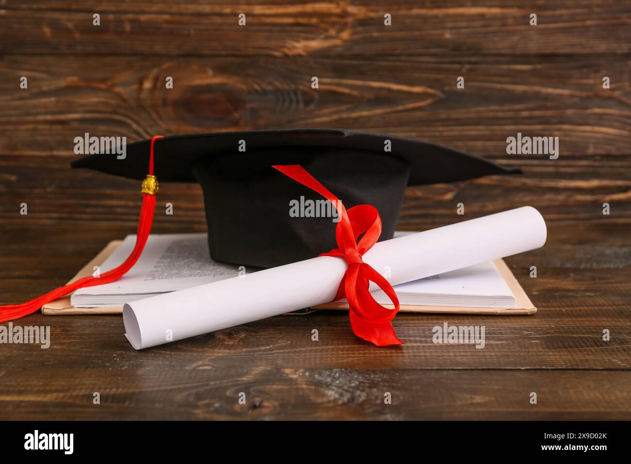 Diploma con libro e mortaio su fondo in legno Foto Stock
