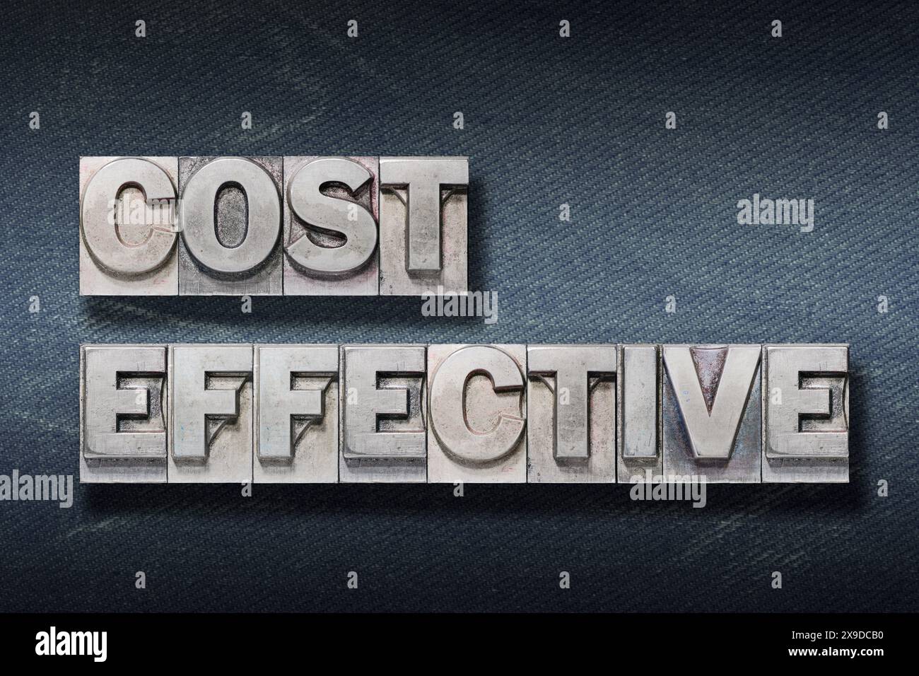 frase economica realizzata in letterpress metallizzato su sfondo jeans scuro Foto Stock