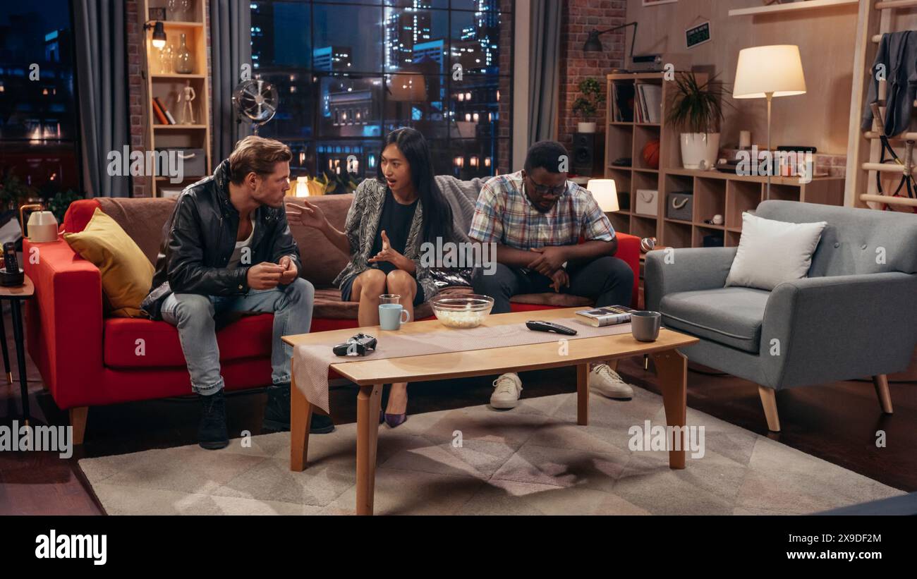 Concetto di sitcom televisiva. Tre amici diversi che si divertono nel salotto. TV Show Funny Sketch su come spiegare una cosa semplice. Screengrab della serie comica sul canale di rete o sul servizio di streaming. Foto Stock
