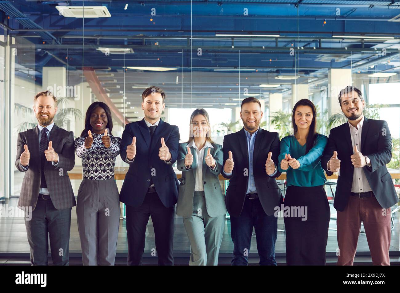 Ritratto di gruppo del team aziendale che mostra i pollice in ufficio Foto Stock