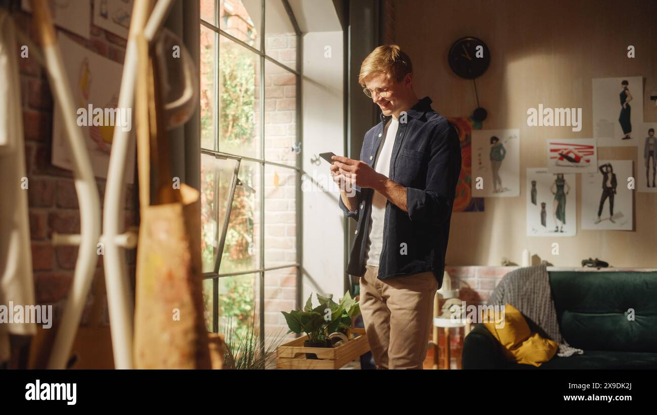 Uomo caucasico che usa lo smartphone mentre riposa a casa. Happy male Blogger creazione di contenuti divertenti e chat con gli iscritti su Internet. Utilizzo dei social network. Foto Stock