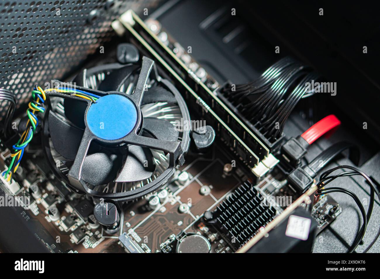 Vista ravvicinata della scheda madre di un computer con ventola della CPU e vari componenti. Foto Stock