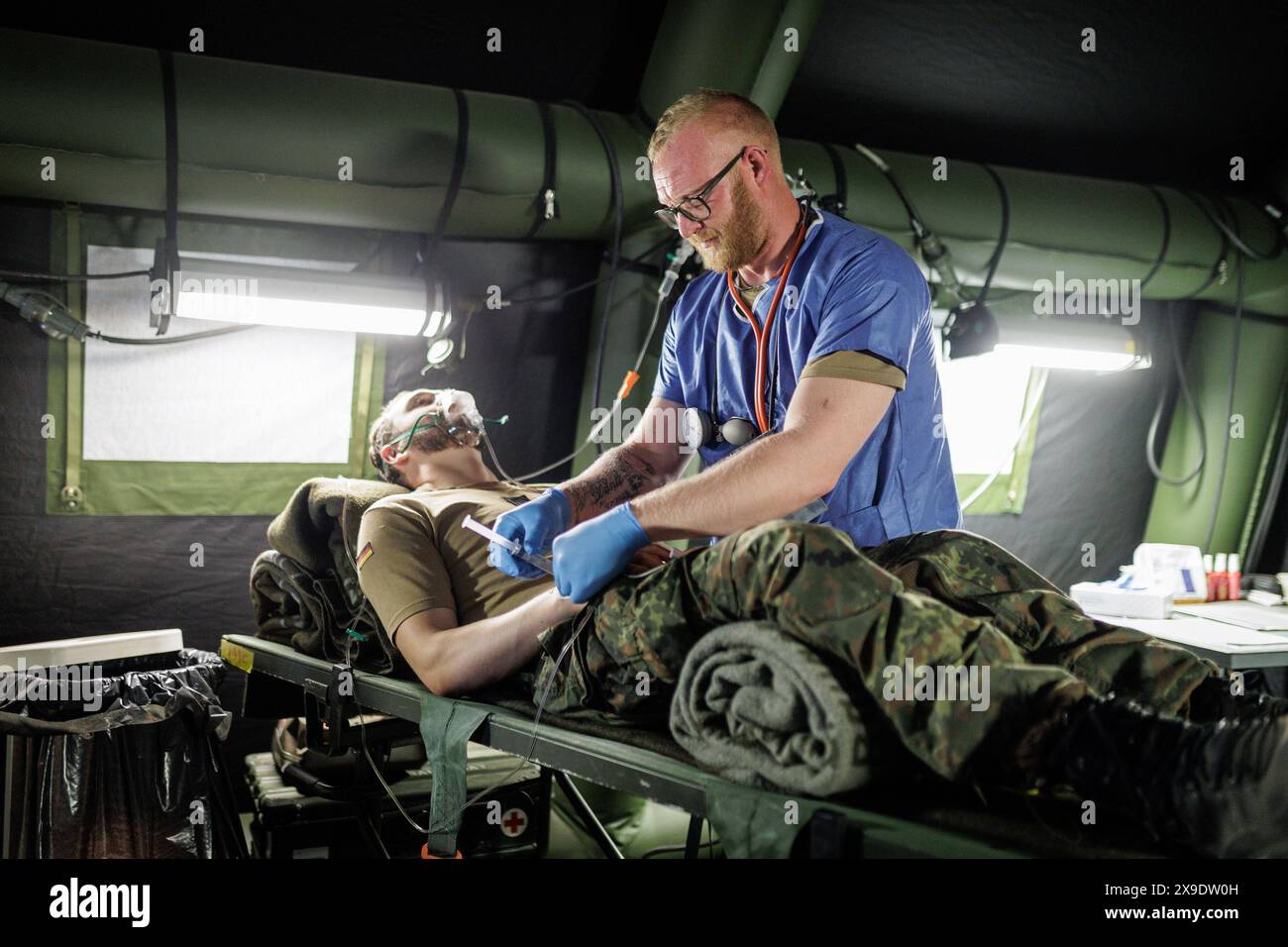 Aerzte und Sanitaeter des Sanitaetsdienstes der Bundeswehr simulieren die Versorgung von Verwundeten unter Einsatzbedingungen. Aufgenommen im Rahmen des NATO-Grossmanoevers Steadfast Defender und dem deutschen Anteil der Uebung, Quadriga 2024, in Pabrade, 29.05.2024. Pabrade Litauen *** i medici e i paramedici del servizio medico delle forze armate tedesche simulano la cura dei feriti in condizioni operative registrate come parte della manovra maggiore NATO Steadfast Defender e la parte tedesca dell'esercitazione, Quadriga 2024, a Pabrade, 29 05 2024 Pabrade Lituania Copyright: XJulianexSonntagx Foto Stock