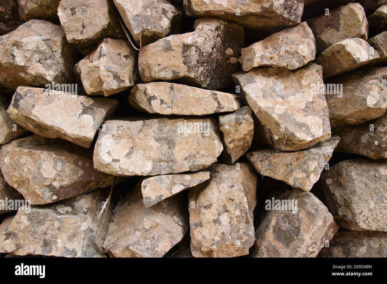 Sfondo naturale di antiche rocce che costituiscono un muro di contenimento nell'ambiente naturale Foto Stock