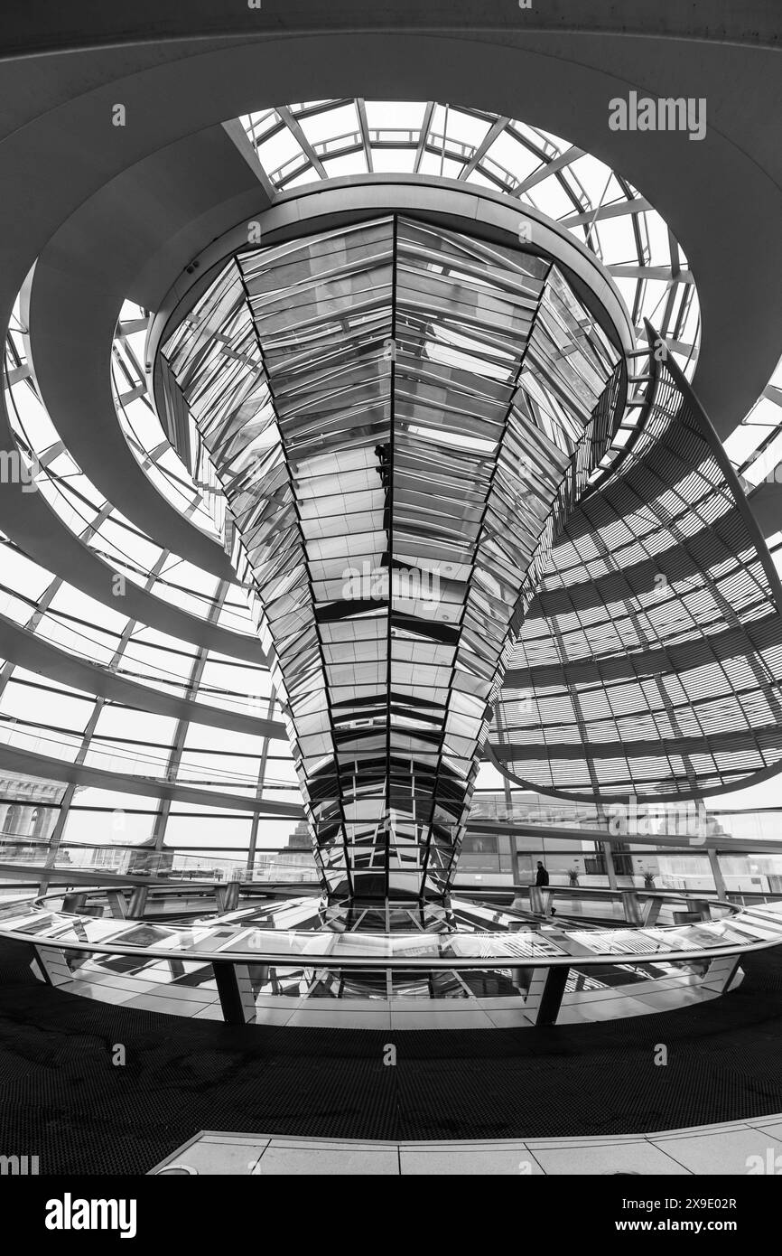 La passerella a spirale e il design moderno della cupola di vetro in cima al Berlins Reichstag Building sotto un cielo nuvoloso. La sede del Bundestag tedesco, Berlino, Germania. Immagine in bianco e nero. Foto Stock