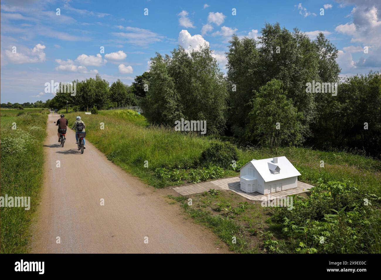 Kamen, Ruhrgebiet, Nordrhein-Westfalen, Deutschland - Fruehlingslandschaft am Seseke-Weg. Die renaturierte Seseke, ein Nebenfluss der Lippe, wurde zum naturnahem Gewaesser umgestaltet. Entlang des renaturierten Flusses entstand zwischen Lünen und Bönen der Seseke-Weg, ein fuss- und Fahrradweg. Radfahrer und Spaziergaenger können entlang des Weges zahlreiche Kunstwerke entdecken, Die im Rahmen des Projektes über WASSER GEHEN entstanden sind. Hier das Kunstwerk arriva di nuovo la pioggia von Wolke Köbberling und Martin Kaltwasser. Kamen Nordrhein-Westfalen Deutschland *** Kamen, regione della Ruhr, nord Foto Stock