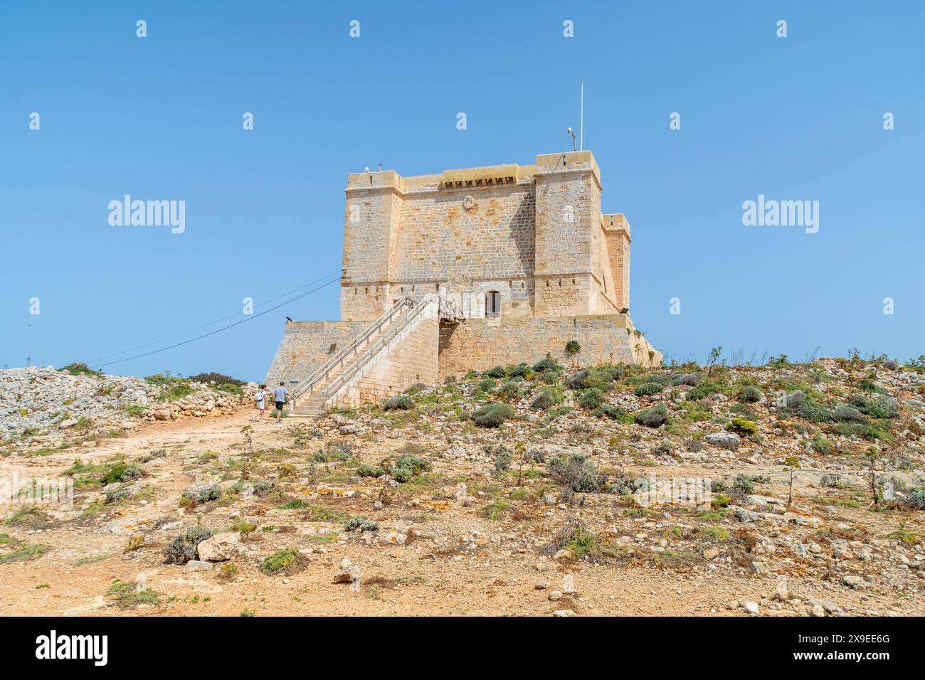 Comino, Malta - 4 maggio 2022: Turisti ai gradini della Torre di Santa Maria, una torre Wignacourt nota anche come Torre Comino, costruita nel 1618. Foto Stock