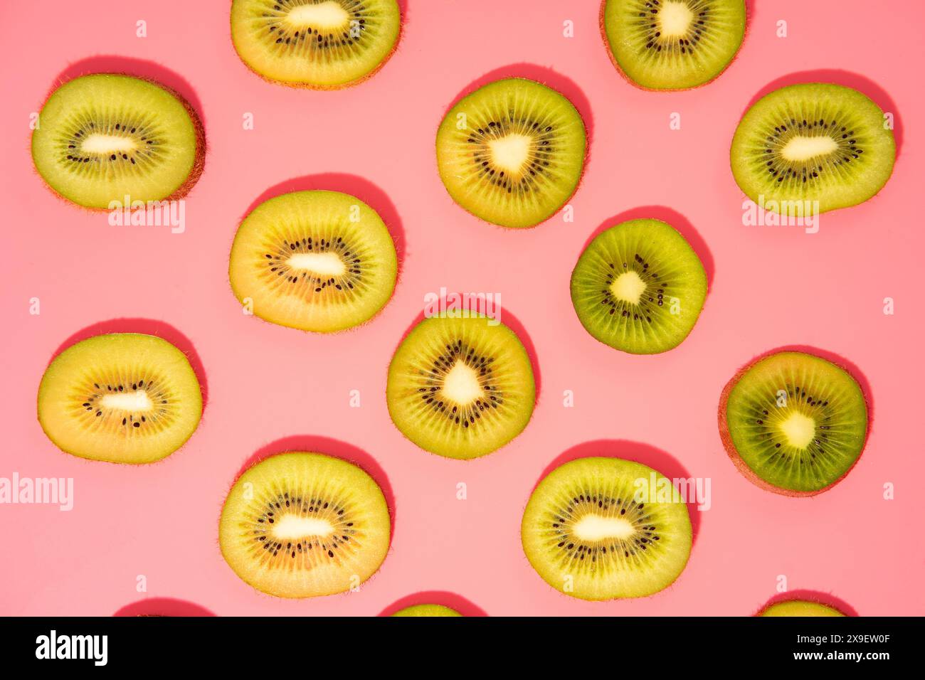 Stesa piatta di fette di kiwi su sfondo rosa Foto Stock