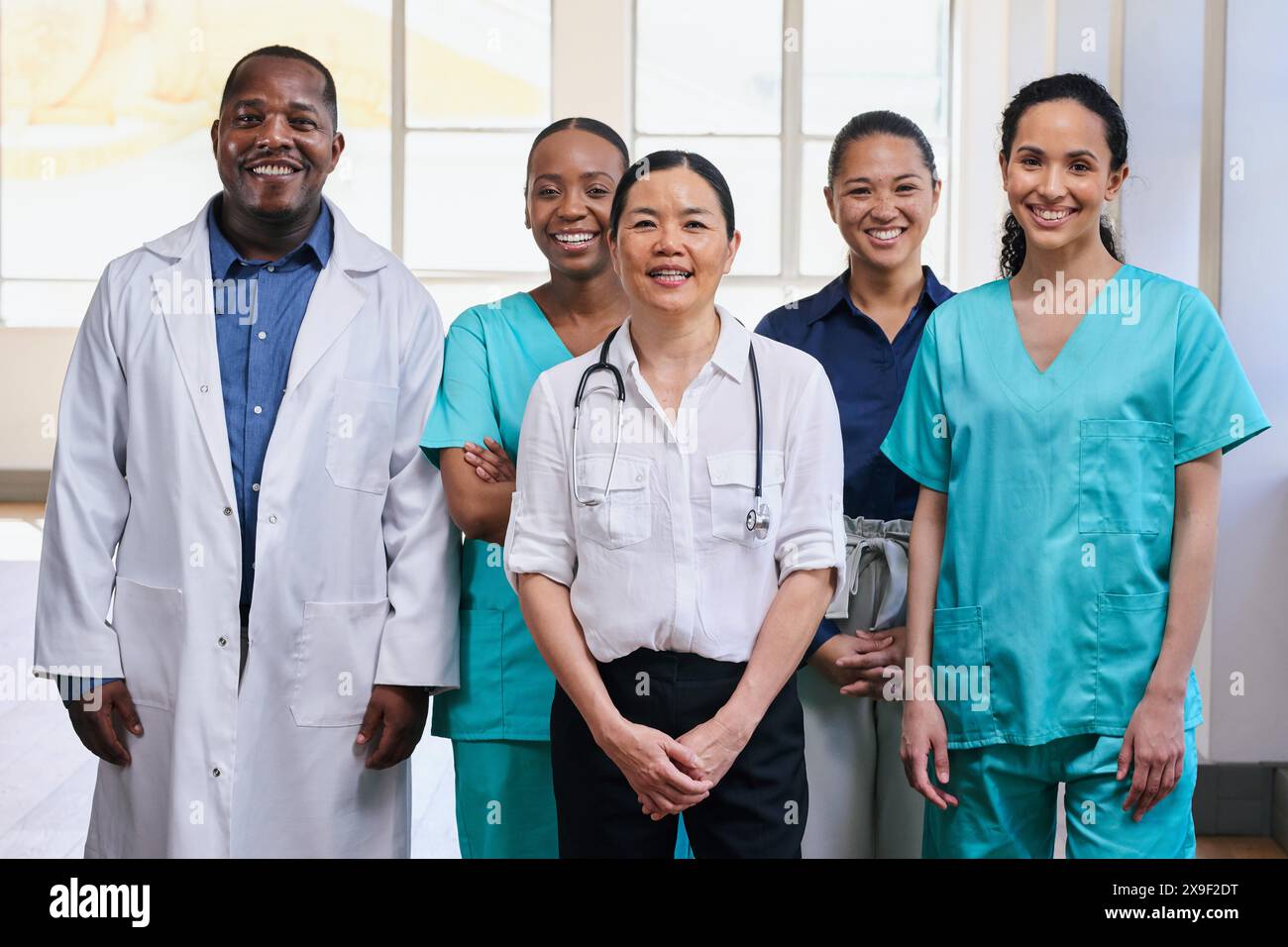 Squadra medica diversificata in piedi insieme in ospedale, sorridente Foto Stock