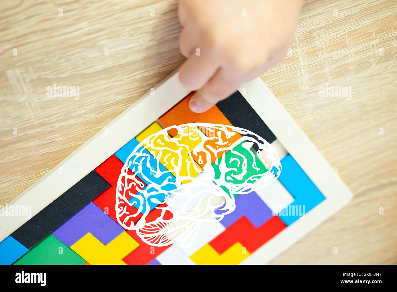 le mani dei bambini esplorano il mondo intricato puzzle in legno colorato, lo sviluppo del cervello, le abilità cognitive, l'immaginazione e le capacità di risoluzione dei problemi Foto Stock