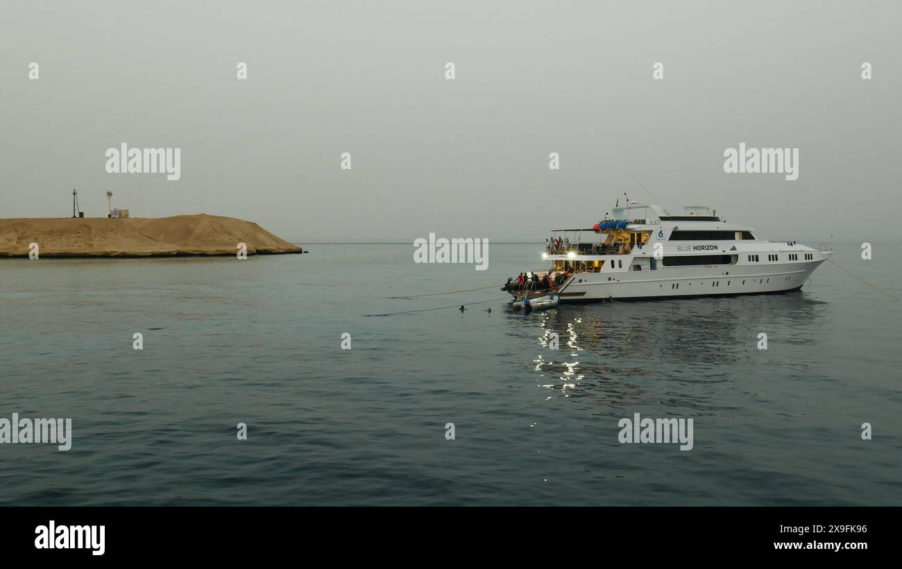 Una barca per immersioni consente ai subacquei di esplorare le barriere coralline e i relitti nel Mar Rosso in un'immersione serale. Foto Stock