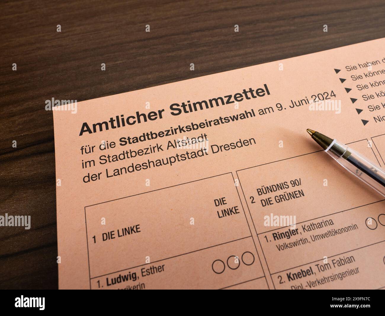 Amtlicher Stimmzettel (voto ufficiale) per le Stadtbezirksbeiratswahl (elezioni municipali) del 2024 a Dresda, Germania. Penna appoggiata sulla carta. Foto Stock