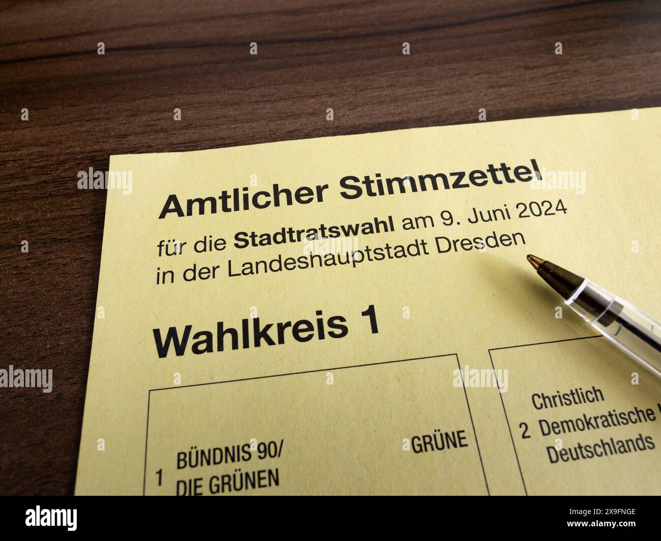 Amtlicher Stimmzettel (voto ufficiale) per le Stadtatswahl (elezioni municipali) del 2024 a Dresda, Germania. Penna adagiata sul documento di voto. Foto Stock