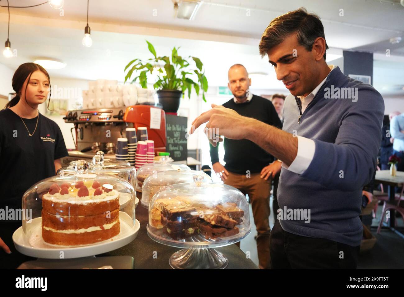 Il primo ministro Rishi Sunak guarda le torte in una bancarella al Burrs Country Park di Bury, mentre si trova sulle tracce della campagna elettorale generale. Data foto: Venerdì 31 maggio 2024. Foto Stock