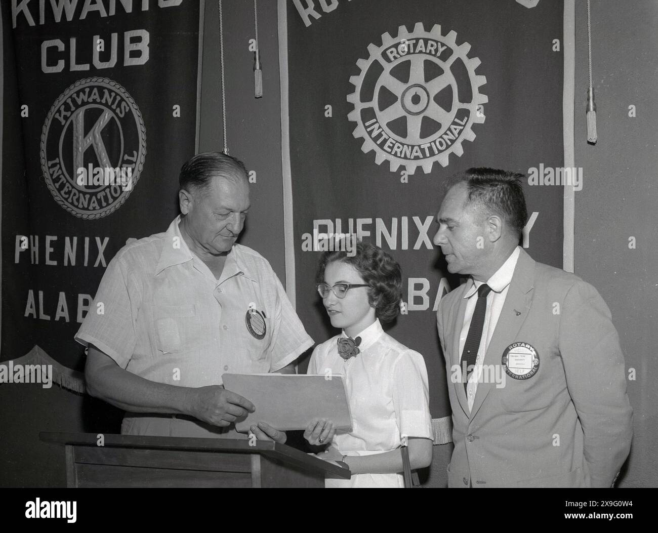 1950, storica, una giovane donna sul palco di un leggio che riceve un premio in una presentazione del Kiwanis Club & Rotary Club di Phoenix, Alabama, USA. Il Rotary è iniziato nel 1905 a Chicago e i Rotary Club sono stati istituiti in tutta l'America per creare connessioni all'interno della comunità basate sull'amicizia e sul servizio. La prova a quattro vie per i rotariani è deragliata da queste domande; è la verità?, è giusto per tutti gli interessati? creerà buona volontà e migliori amicizie? e sarà benefico per tutti gli interessati. Foto Stock