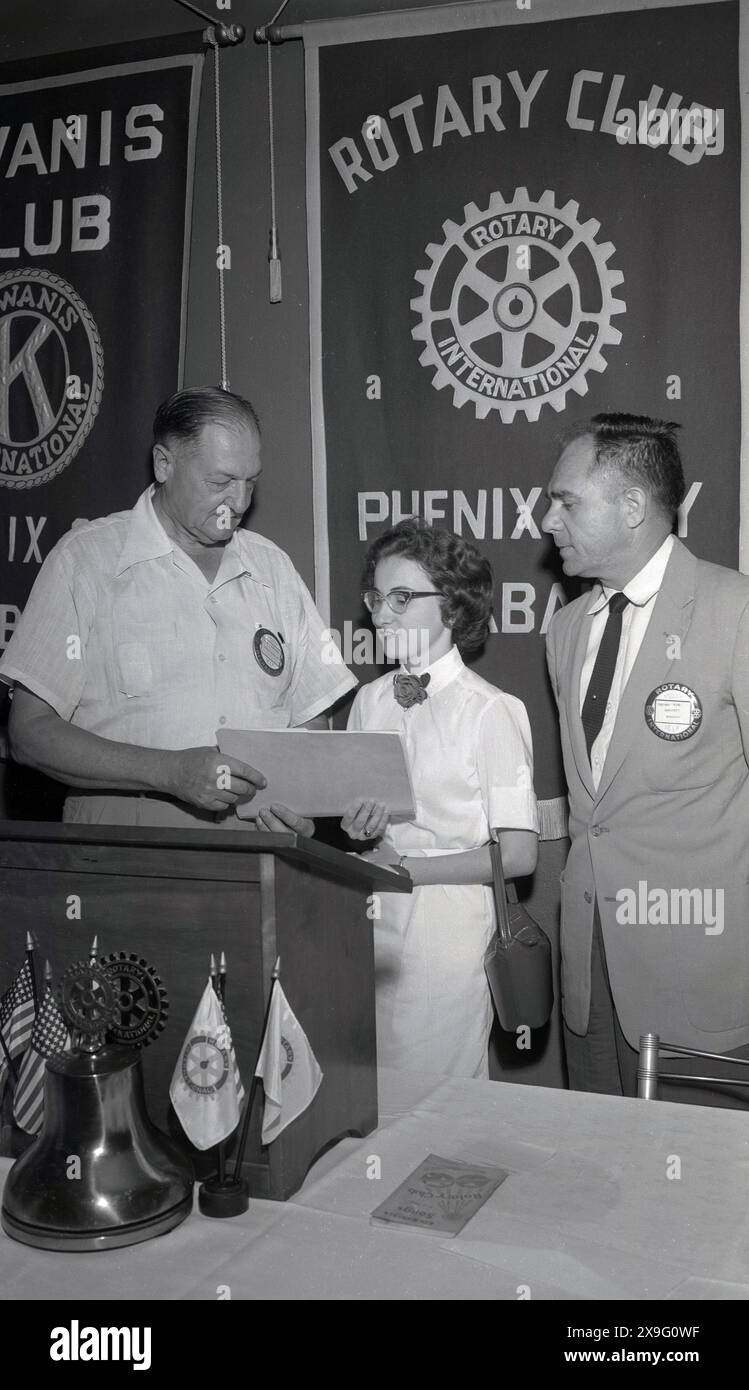 1950, storica, una giovane donna sul palco di un leggio che riceve un premio in una presentazione del Kiwanis Club & Rotary Club di Phoenix, Alabama, USA. Il Rotary è iniziato nel 1905 a Chicago e i Rotary Club sono stati istituiti in tutta l'America per creare connessioni all'interno della comunità basate sull'amicizia e sul servizio. La prova a quattro vie per i rotariani è deragliata da queste domande; è la verità?, è giusto per tutti gli interessati? creerà buona volontà e migliori amicizie? e sarà benefico per tutti gli interessati. Foto Stock