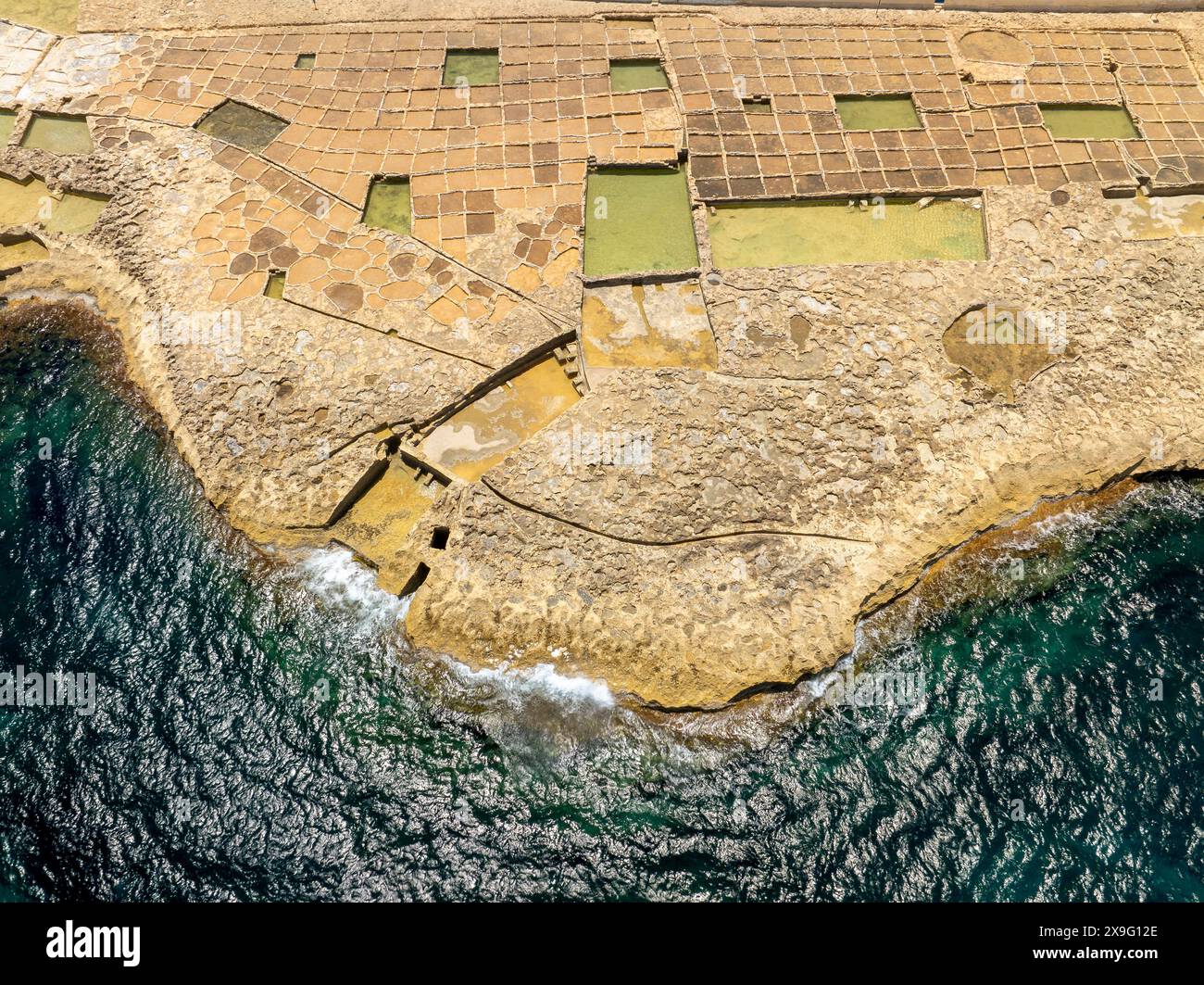 Famosa attrazione turistica dell'isola di Gozo, le saline nella baia di Xwejni, Xwejni, l'isola di Gozo, una parte delle isole di Malta. Foto Stock