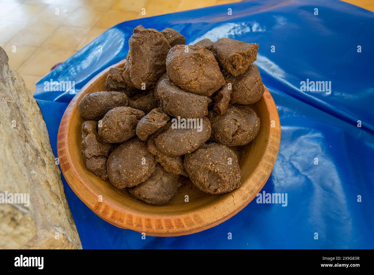Primo piano dei sottoprodotti della produzione di olio di argan in una ciotola di legno. Prova di pratiche sostenibili a Essaouira, Marocco. Foto Stock