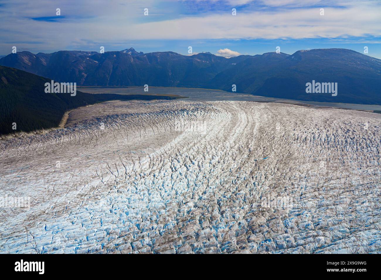 Veduta aerea dei ghiacciai situati lungo la baia di Taku, che fanno parte del Juneau Icefield in Alaska, USA - Curvy flusso di ghiaccio coperto di cesoia Foto Stock