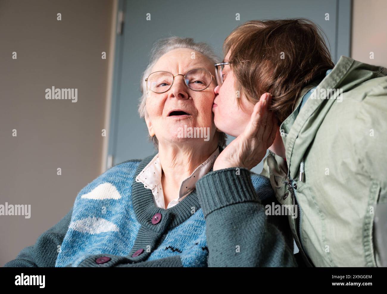 Figlia della sindrome di Down che abbraccia 85 anni madre bianca, Tienen, Fiandre, Belgio. Modello rilasciato. Foto Stock