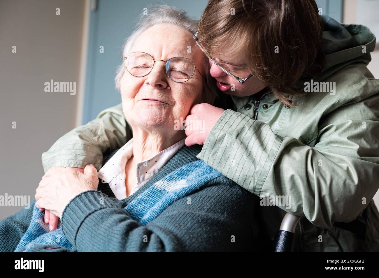 Figlia della sindrome di Down che abbraccia 85 anni madre bianca, Tienen, Fiandre, Belgio. Modello rilasciato. Foto Stock