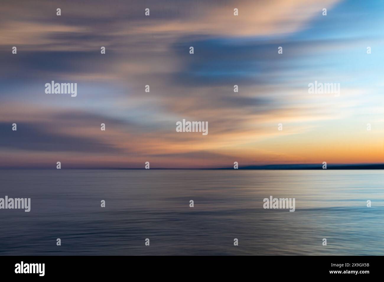 ICM, nel movimento della telecamera, tramonto sull'oceano, cielo parzialmente nuvoloso, astratto Foto Stock