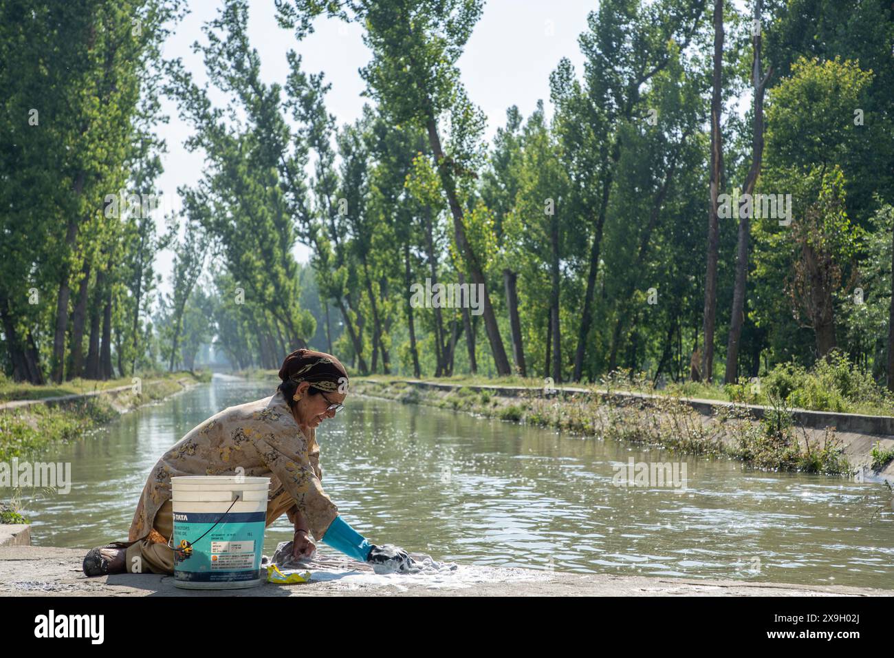 31 maggio 2024, Srinagar, Jammu e Kashmir, India: La donna del Kashmir lava i vestiti in un canale d'acqua in una calda giornata estiva a Srinagar, capitale estiva del Jammu e del Kashmir. L'India, la nazione più popolosa del mondo, è stata colpita da una delle sue peggiori striature di caldo di sempre, con molte parti del paese che sperimentano temperature costanti oltre i 50 gradi Celsius, o circa 122 gradi Fahrenheit. L'India Meteorological Department (IMD) ha emesso un allarme rosso per un'ondata di caldo in diverse città del nord dell'India, tra cui la capitale del paese, nuova Delhi, e la regione himalayana del Kashmir. (Credito a me Foto Stock