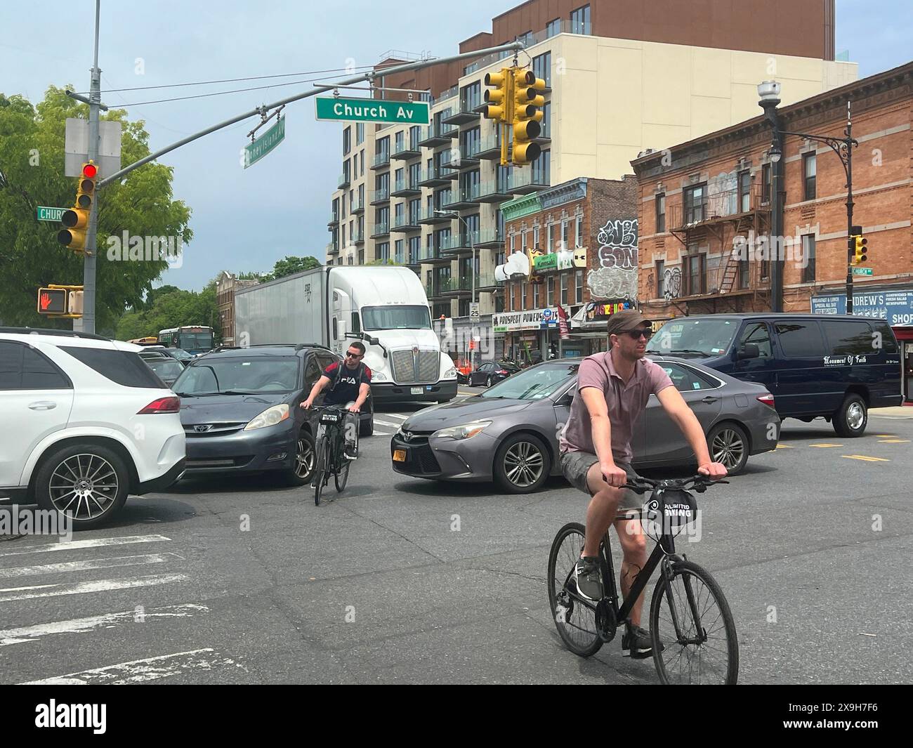 I ciclisti devono stare attenti a condividere le strade e le strade con auto e camion in ambienti urbani densi come New York City. Foto Stock