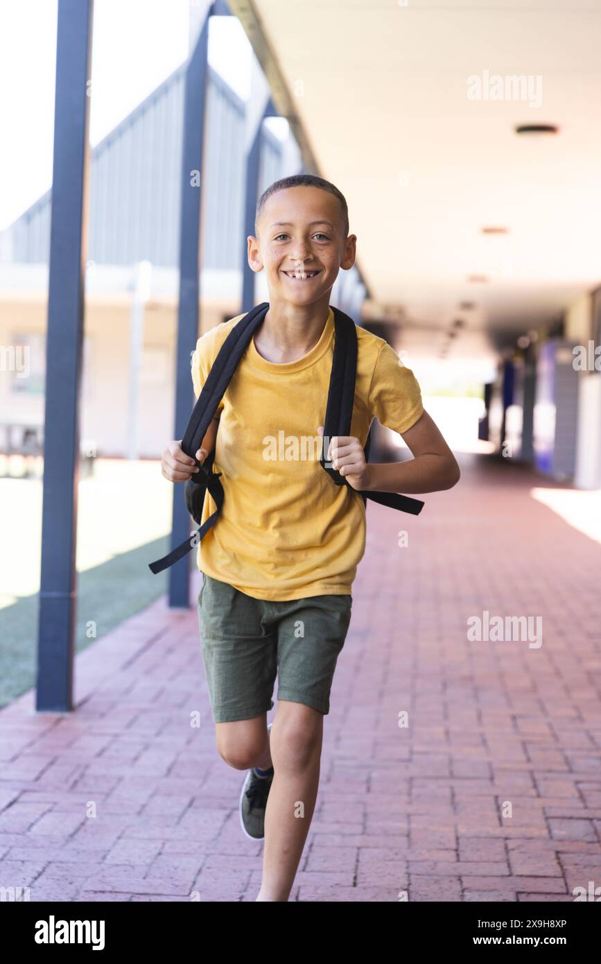 Ragazzo birazziale che corre a scuola Foto Stock