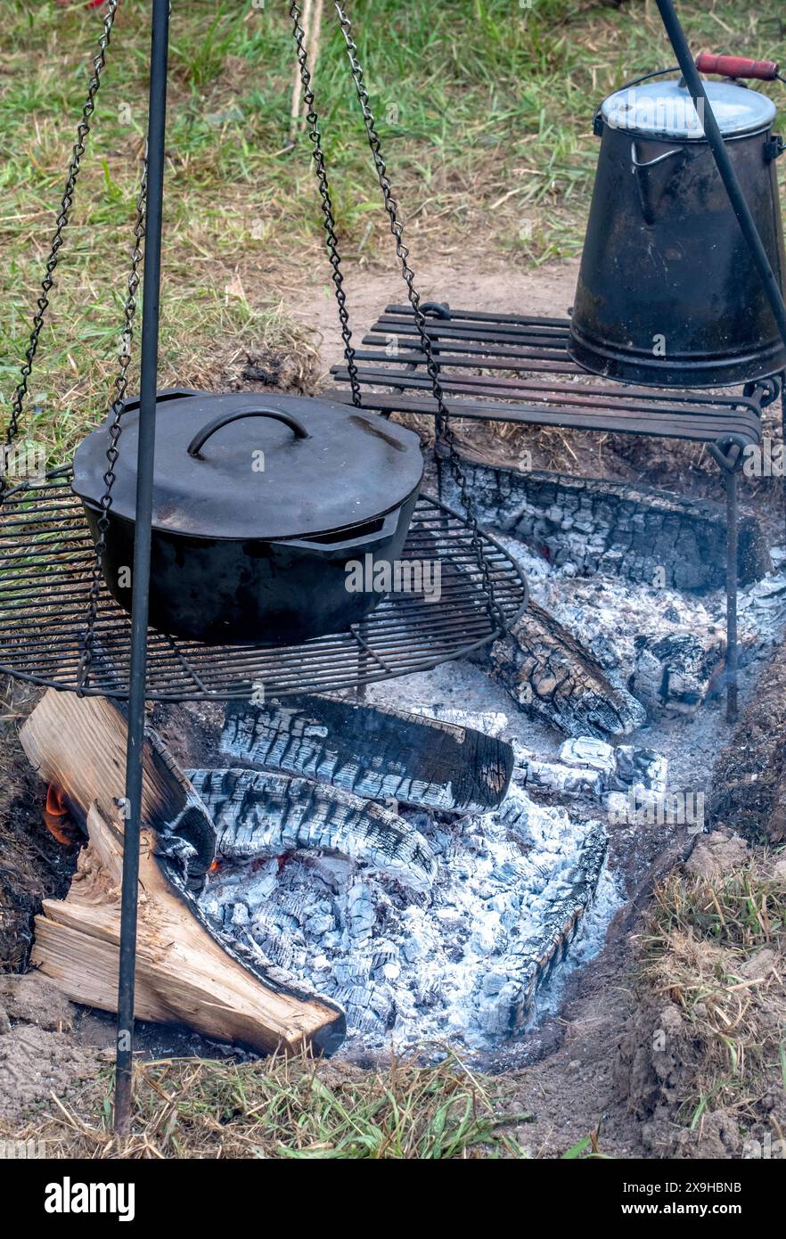 usare la ghisa per cucinare sopra un fuoco aperto in un campo Foto Stock