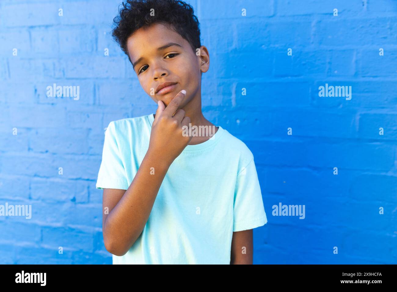 In un ambiente scolastico, un giovane studente afroamericano posa con cura Foto Stock