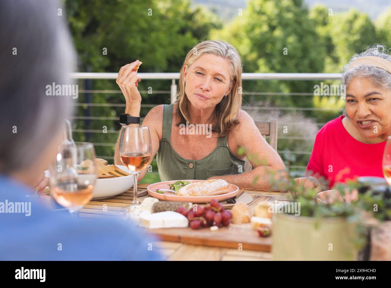 Diverse amiche anziane si godono un pasto all'aperto Foto Stock