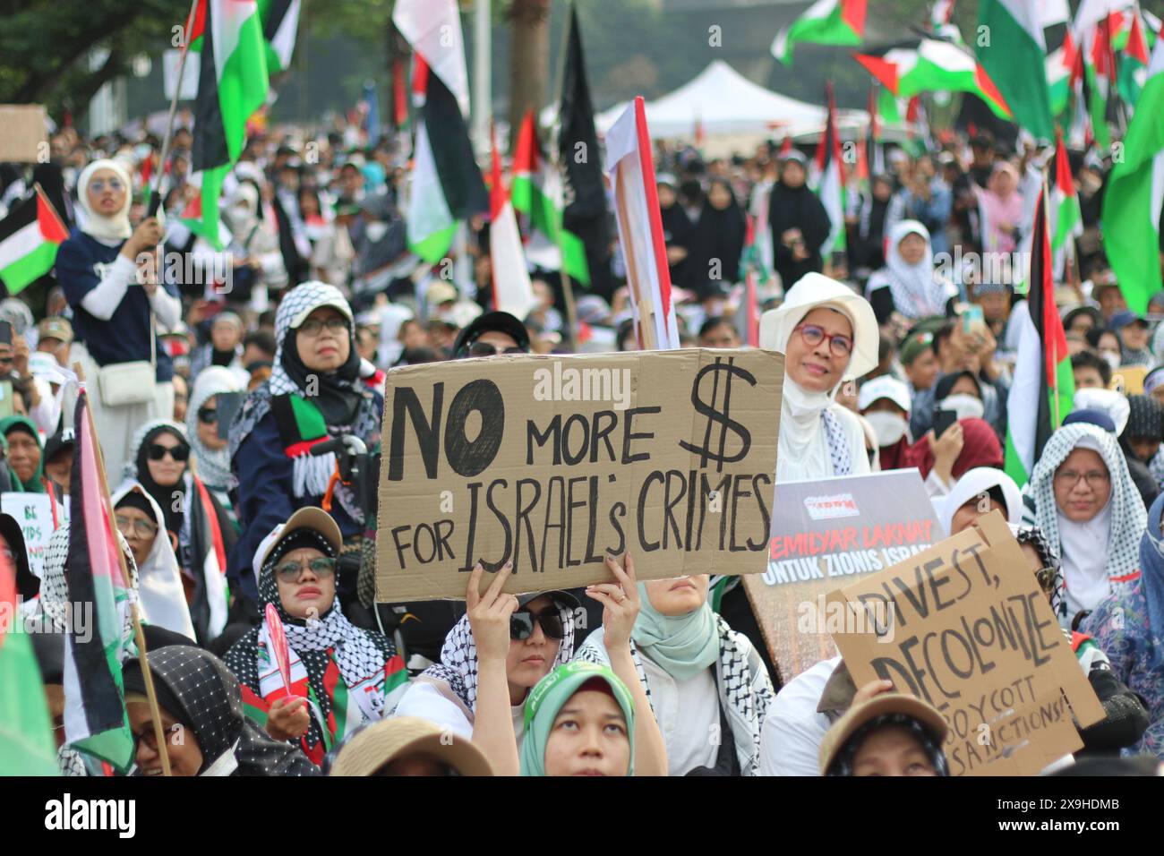 GIACARTA, INDONESIA - 1° GIUGNO: Un manifestante pro-palestinese regge un cartello con la scritta "No More for Israel's Crime” durante la manifestazione pro-palestinese presso l'ambasciata statunitense di fronte a Giacarta, Indonesia, il 1° giugno 2024. La manifestazione ha protestato contro l'attacco militare israeliano a Rafah, Gaza. Foto Stock