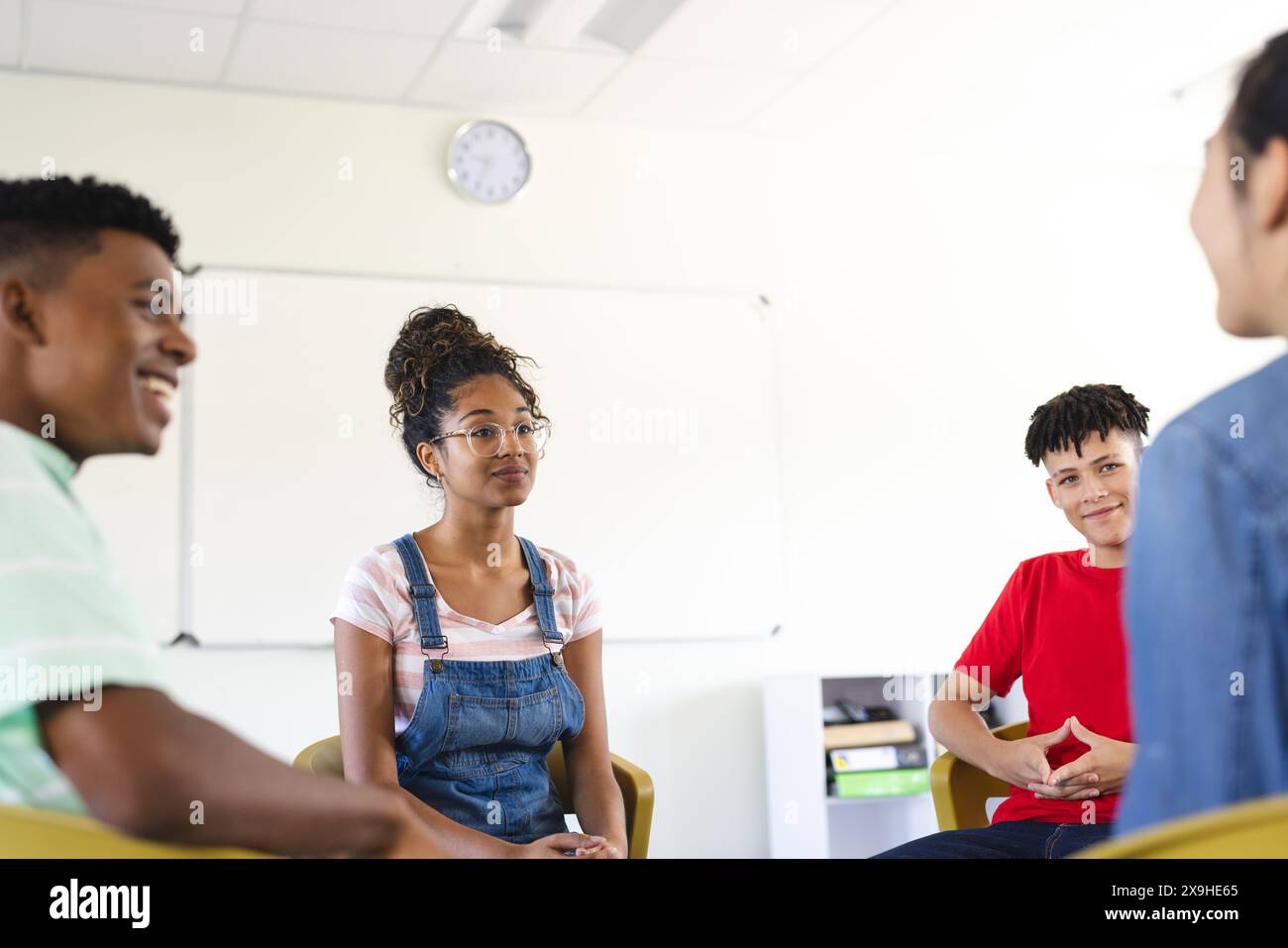 Diversi adolescenti si impegnano in una discussione di gruppo alle superiori Foto Stock