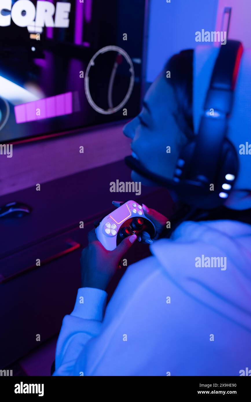 Una giovane donna birazziale che indossa le cuffie e si rilassa a casa Foto Stock