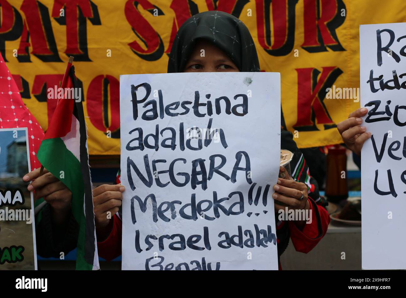 GIACARTA, INDONESIA - 1 GIUGNO: Un manifestante pro-palestinese regge un cartello con la scritta "la Palestina è uno Stato indipendente. Israele è un parassita durante la manifestazione pro-palestinese presso l'ambasciata statunitense di fronte a Giacarta, Indonesia, il 1° giugno 2024. La manifestazione ha protestato contro l'attacco militare israeliano a Rafah, Gaza. Foto Stock