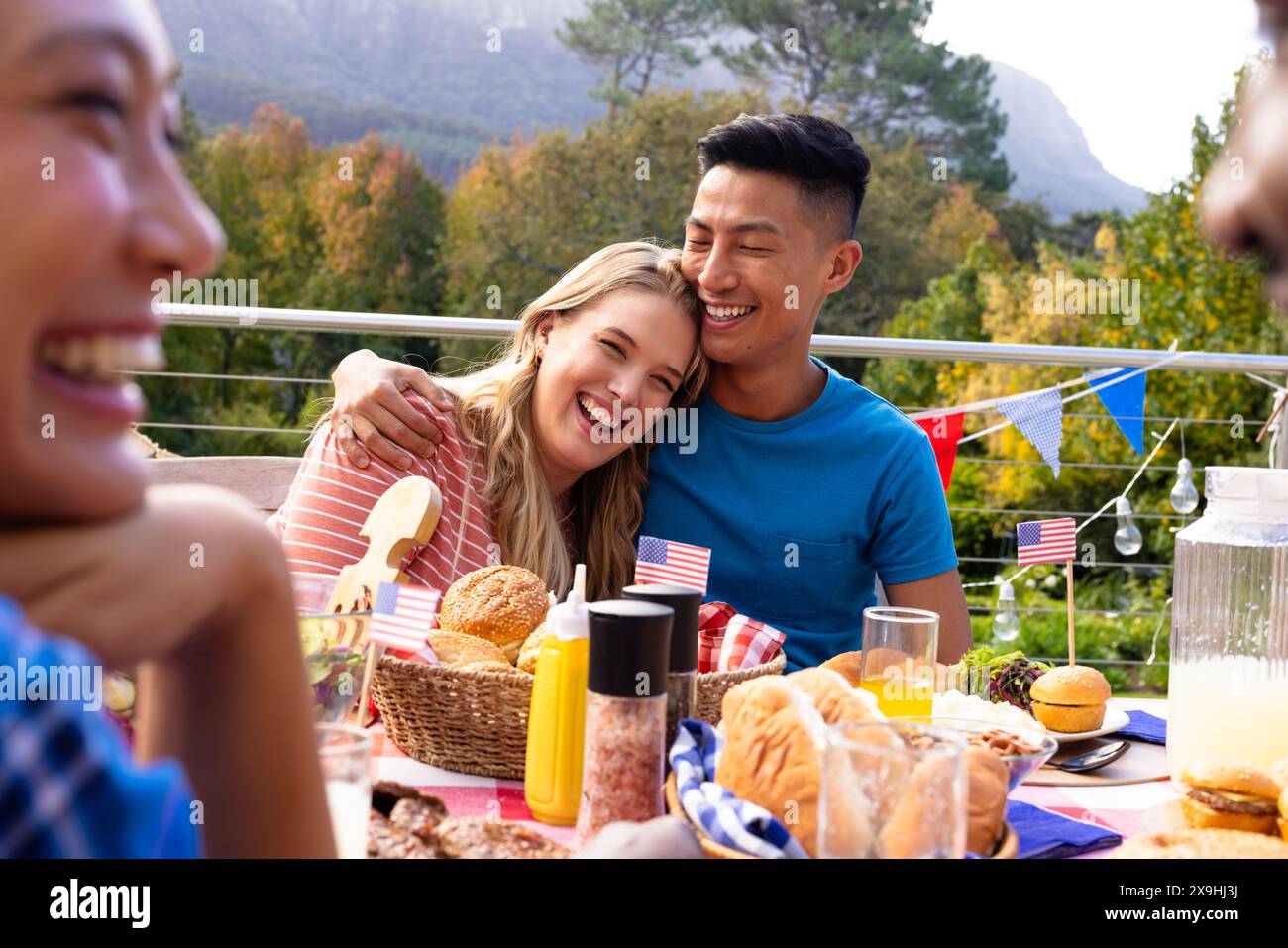 Un gruppo di amici che abbracciano e cenano con le bandiere degli stati uniti Foto Stock