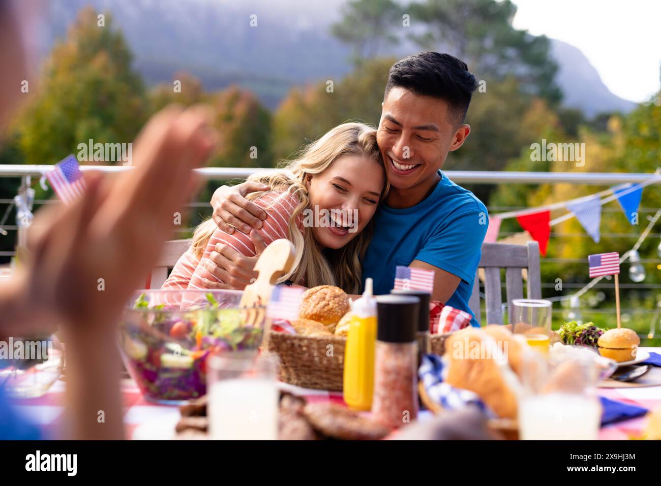 Un gruppo di amici che abbracciano e cenano con le bandiere degli stati uniti Foto Stock