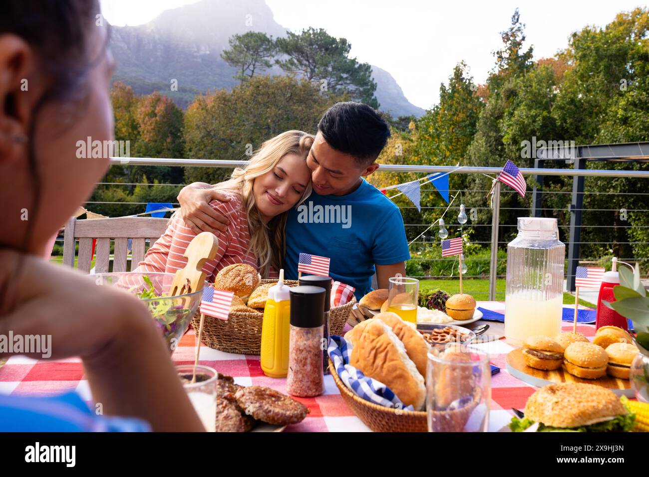 Un gruppo di amici che abbracciano e cenano con le bandiere degli stati uniti Foto Stock