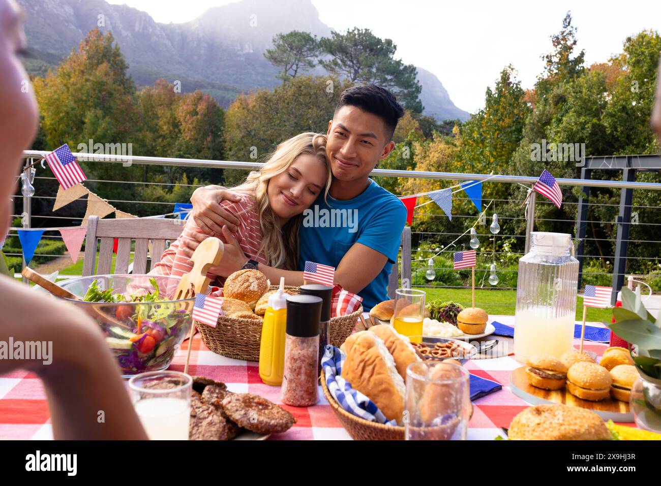 Un gruppo di amici che abbracciano e cenano con le bandiere degli stati uniti Foto Stock