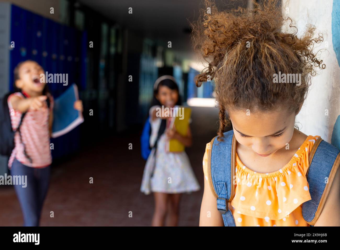 A scuola, tre studentesse birazziali sono nel corridoio, a subire bullismo Foto Stock
