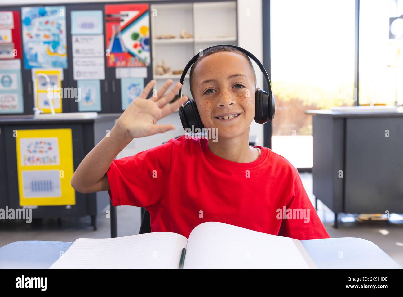 Un ragazzo birazziale ama una sessione di apprendimento a scuola con una videochiamata Foto Stock