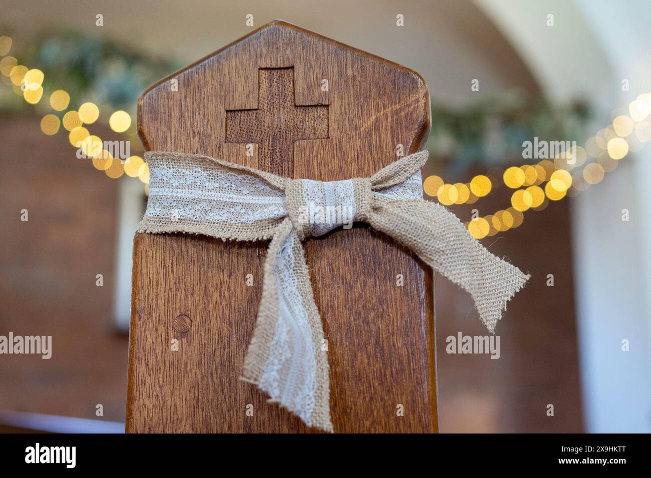 Luci a corde decorate da una chiesa legata a un nastro di pew in legno Foto Stock