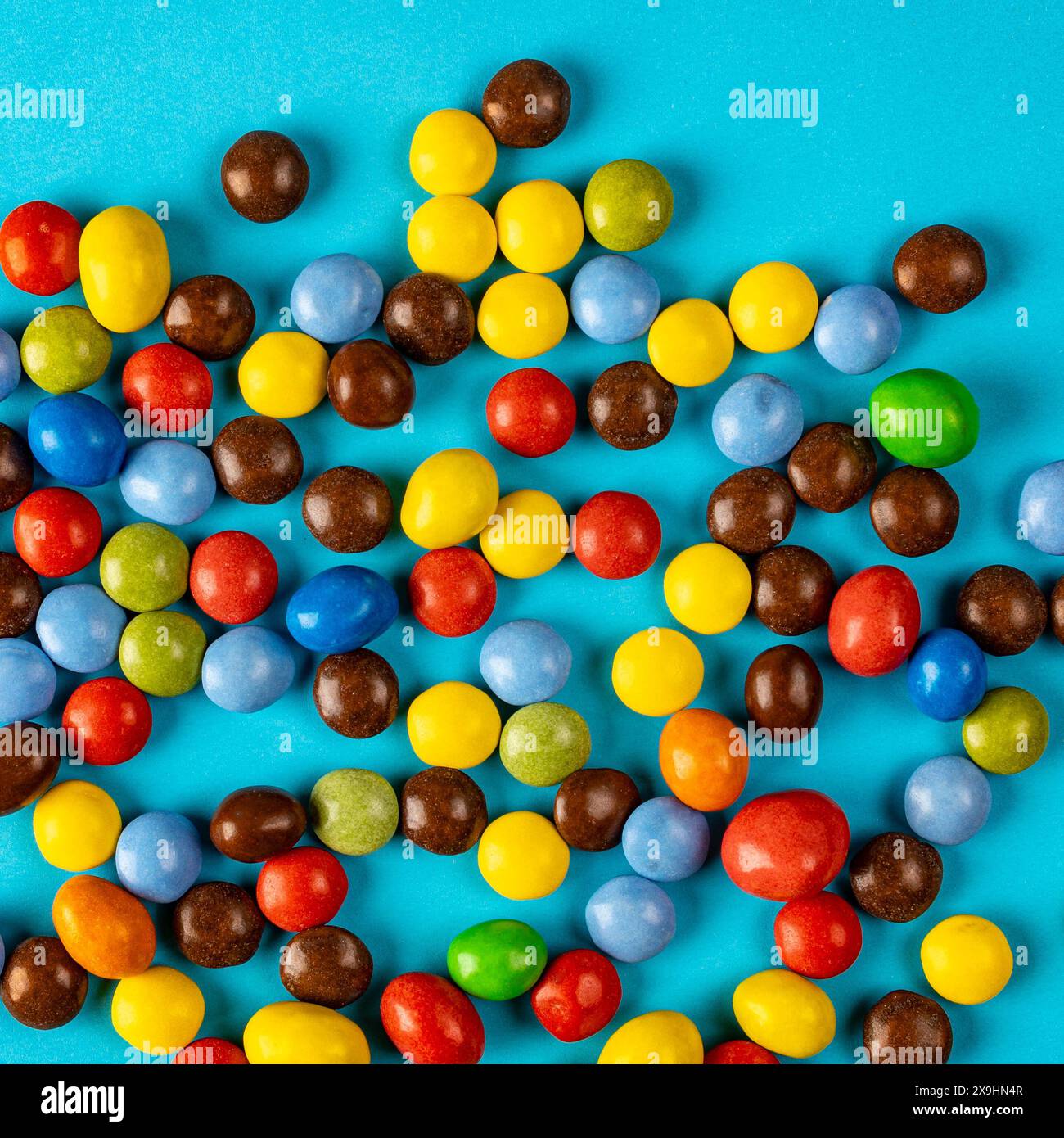 caramelle al cioccolato multicolore su sfondo colorato, foto in studio dall'alto verso il basso Foto Stock