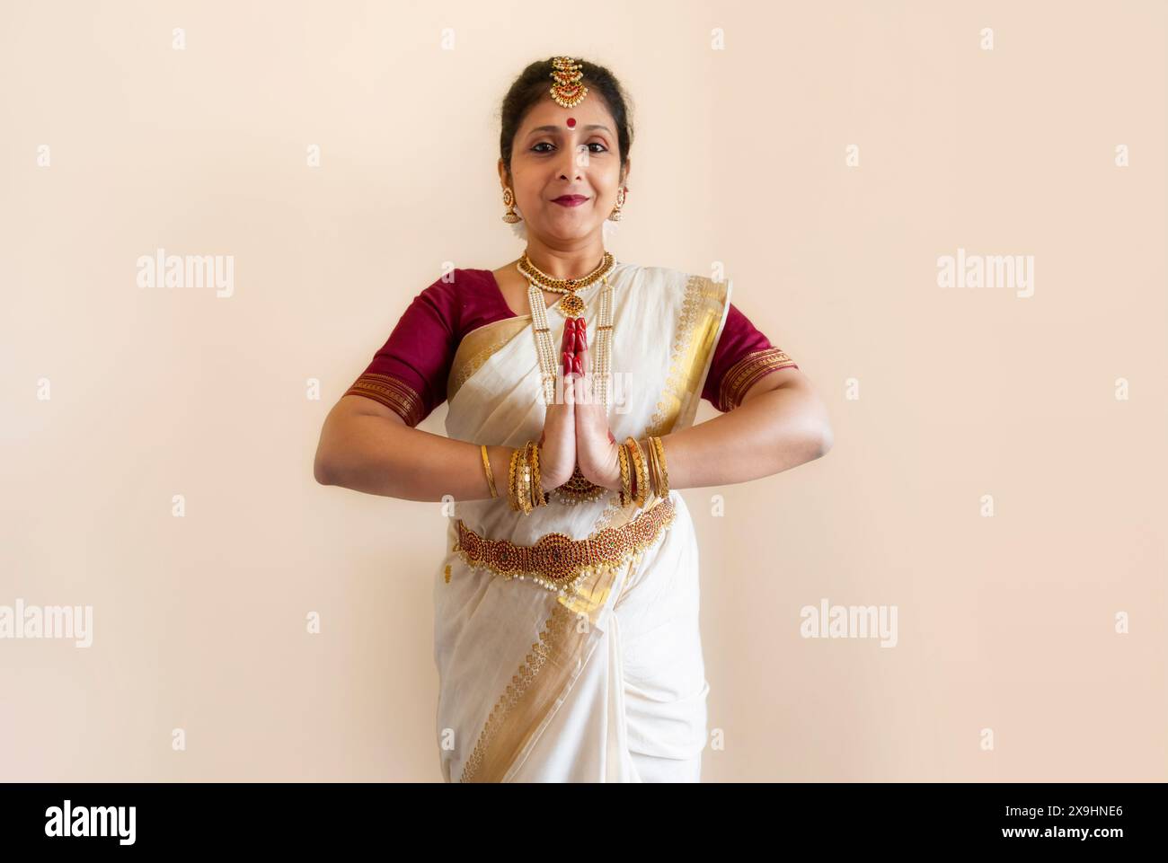 Ballerina classica indiana che dimostra la postura della danza classica di Bharatanatyam su sfondo chiaro Foto Stock