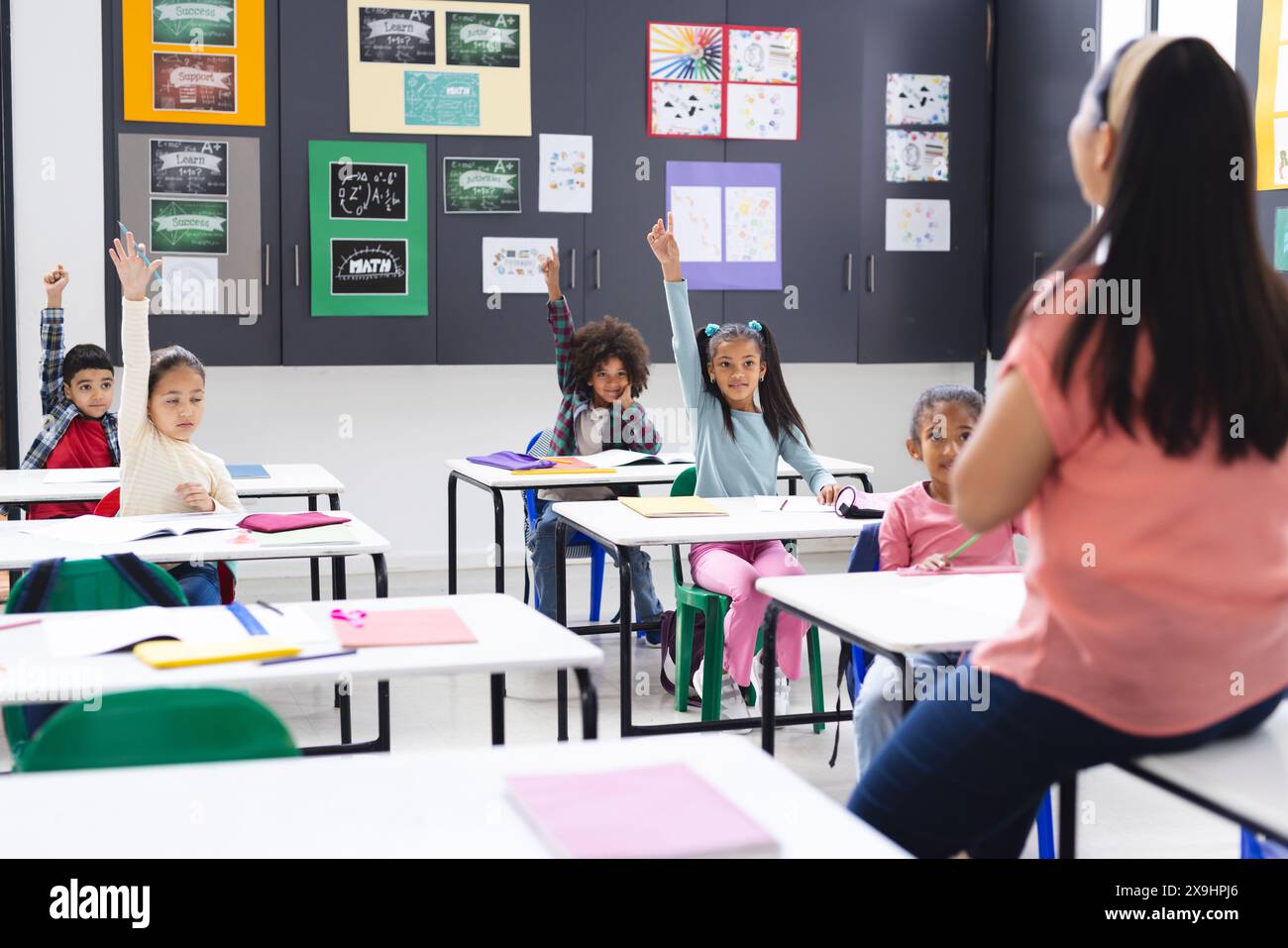 La giovane insegnante birazziale affronta la sua diversa classe in classe scolastica Foto Stock