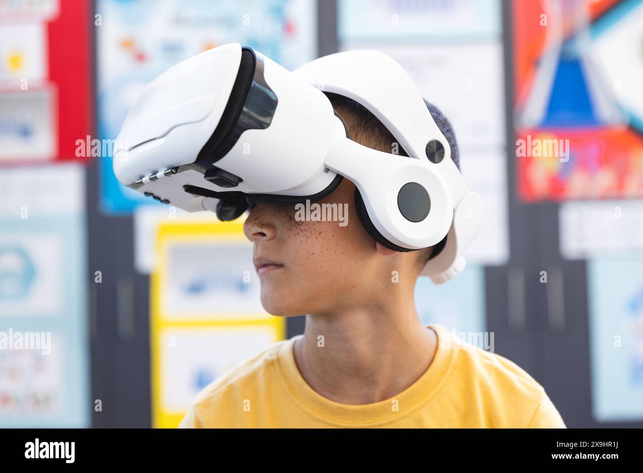 Birazziale ragazzo esplora la realtà virtuale a scuola Foto Stock