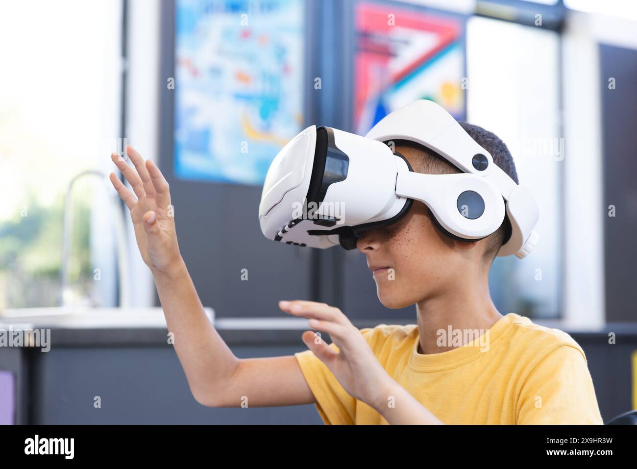 Birazziale ragazzo esplora la realtà virtuale a scuola Foto Stock